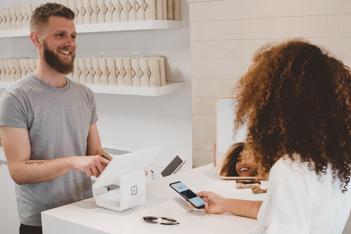 Merchant setting up an online store on laptop at a retail counter