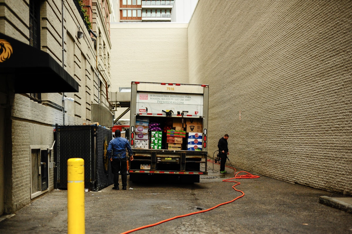 Delivery workers unloading packages from a logistics truck